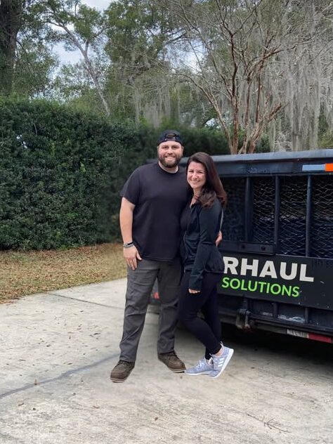 Overhaul Junk Solutions owners standing in front of trailer for furniture removal, applicance removal, yard waste removal, swingset removal, trampoline removal, in the volusia county FL area